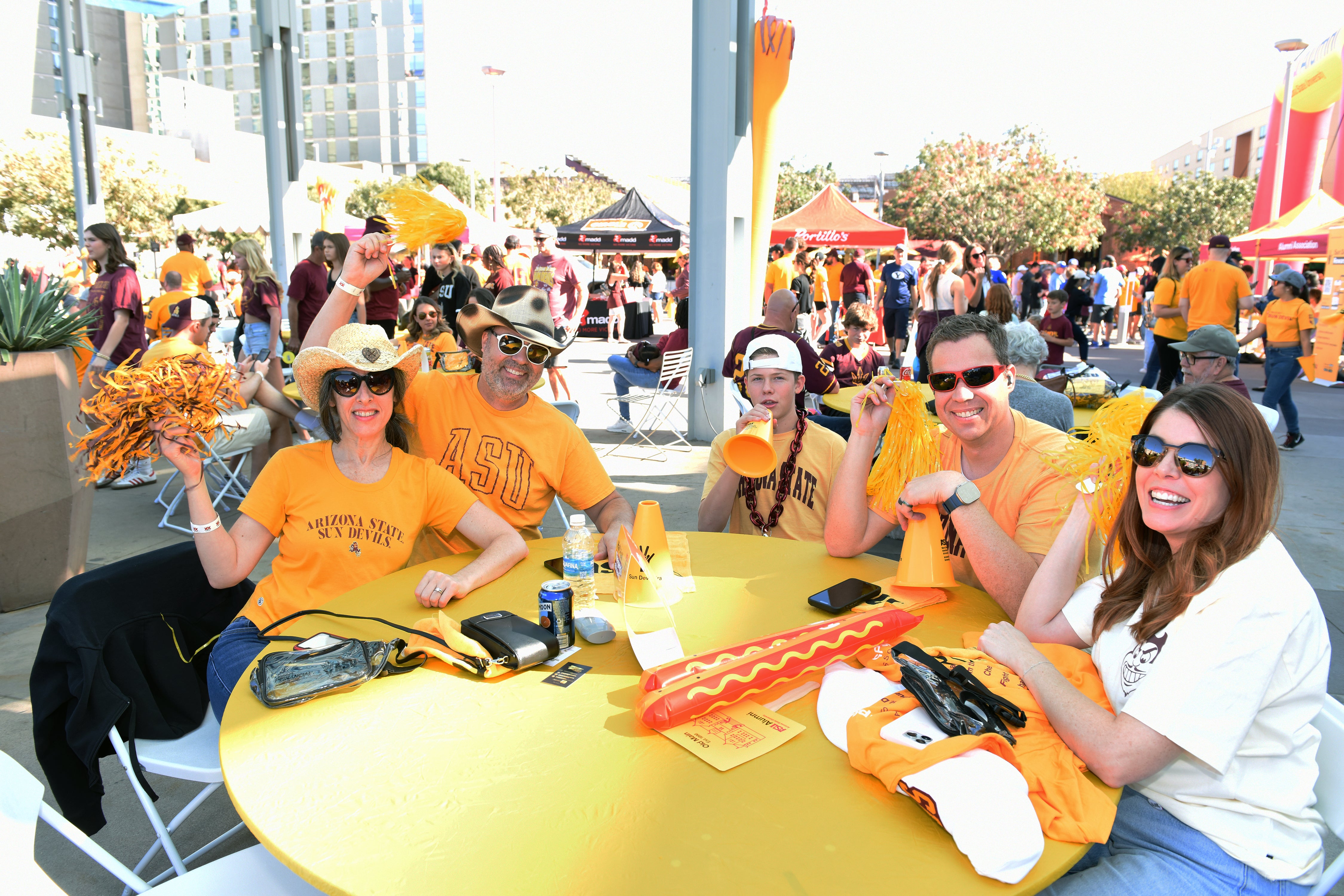 A family at Sparky's Touchdown Tailgate sits smiling. 