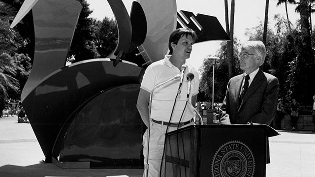 2 people speaking at podium